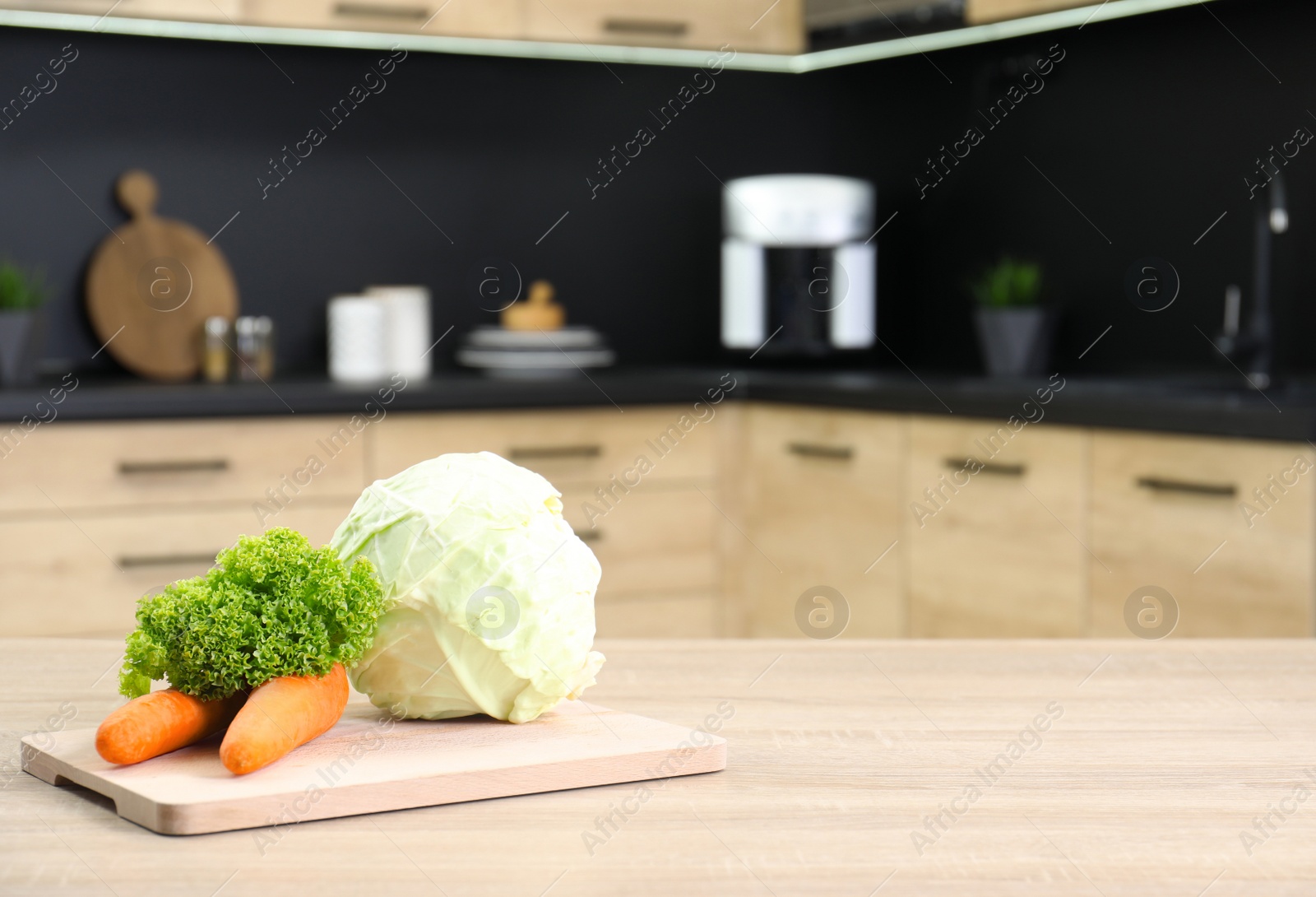 Photo of Fresh vegetables on wooden table in kitchen. Space for text