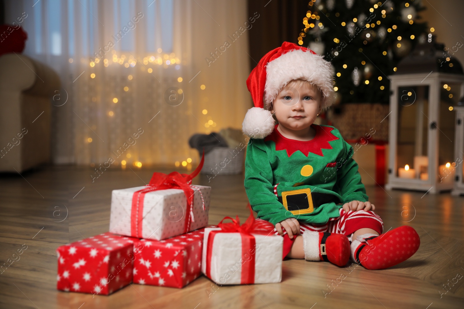 Photo of Baby in cute Christmas outfit with gifts at home