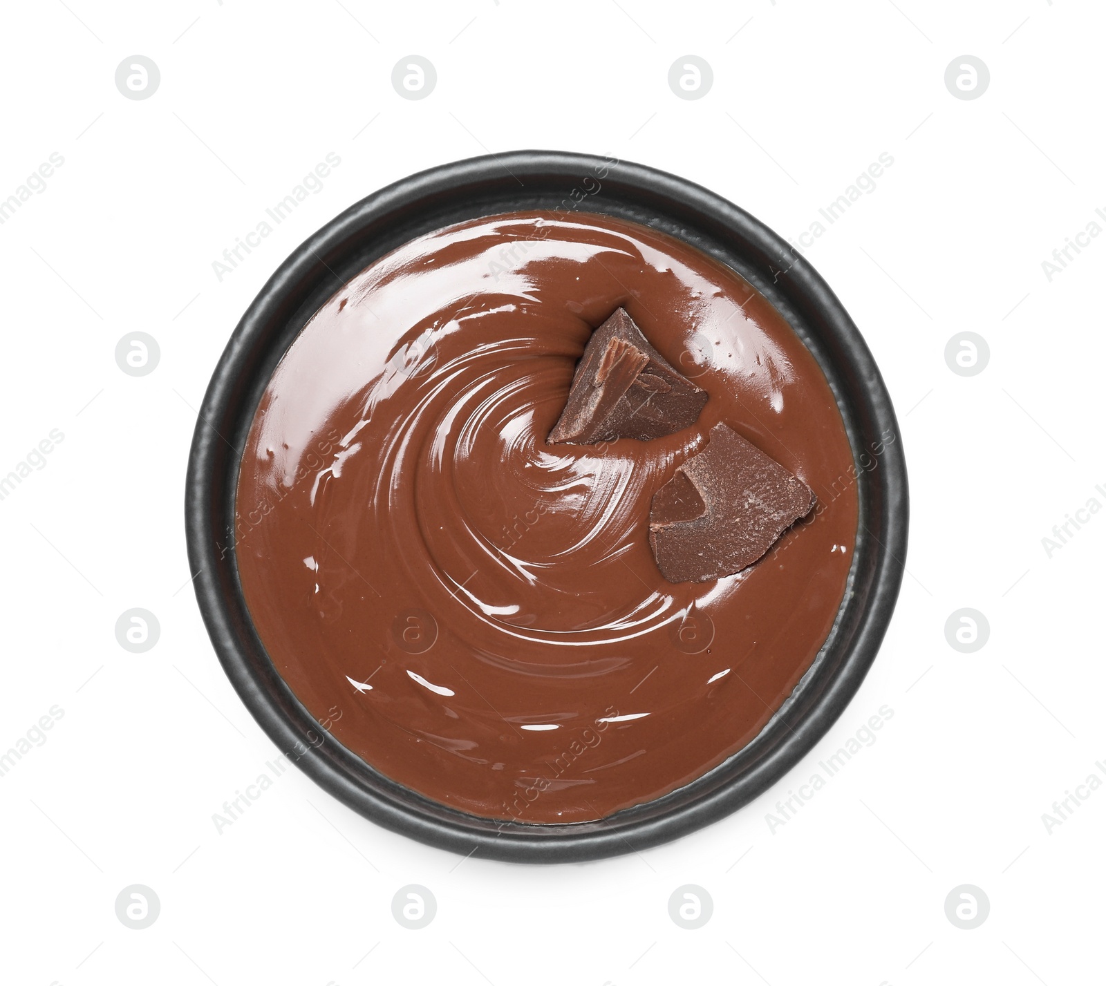 Photo of Tasty milk chocolate paste with pieces in bowl isolated on white, top view