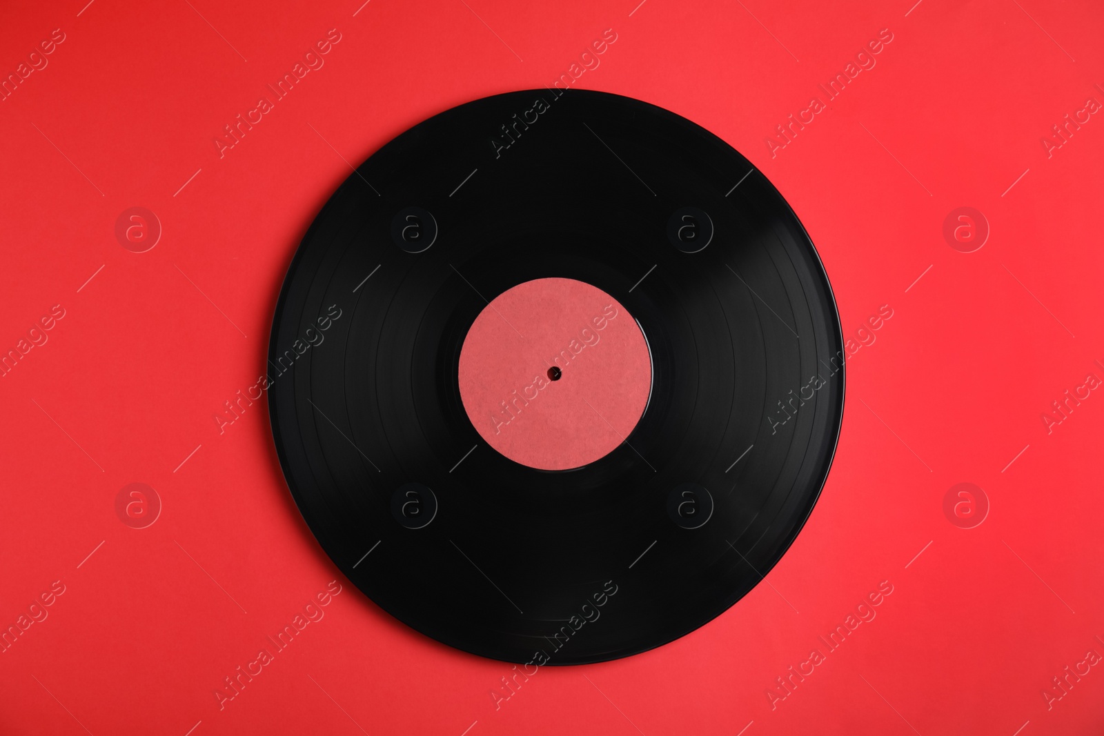 Photo of Vintage vinyl record on red background, top view