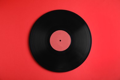 Vintage vinyl record on red background, top view