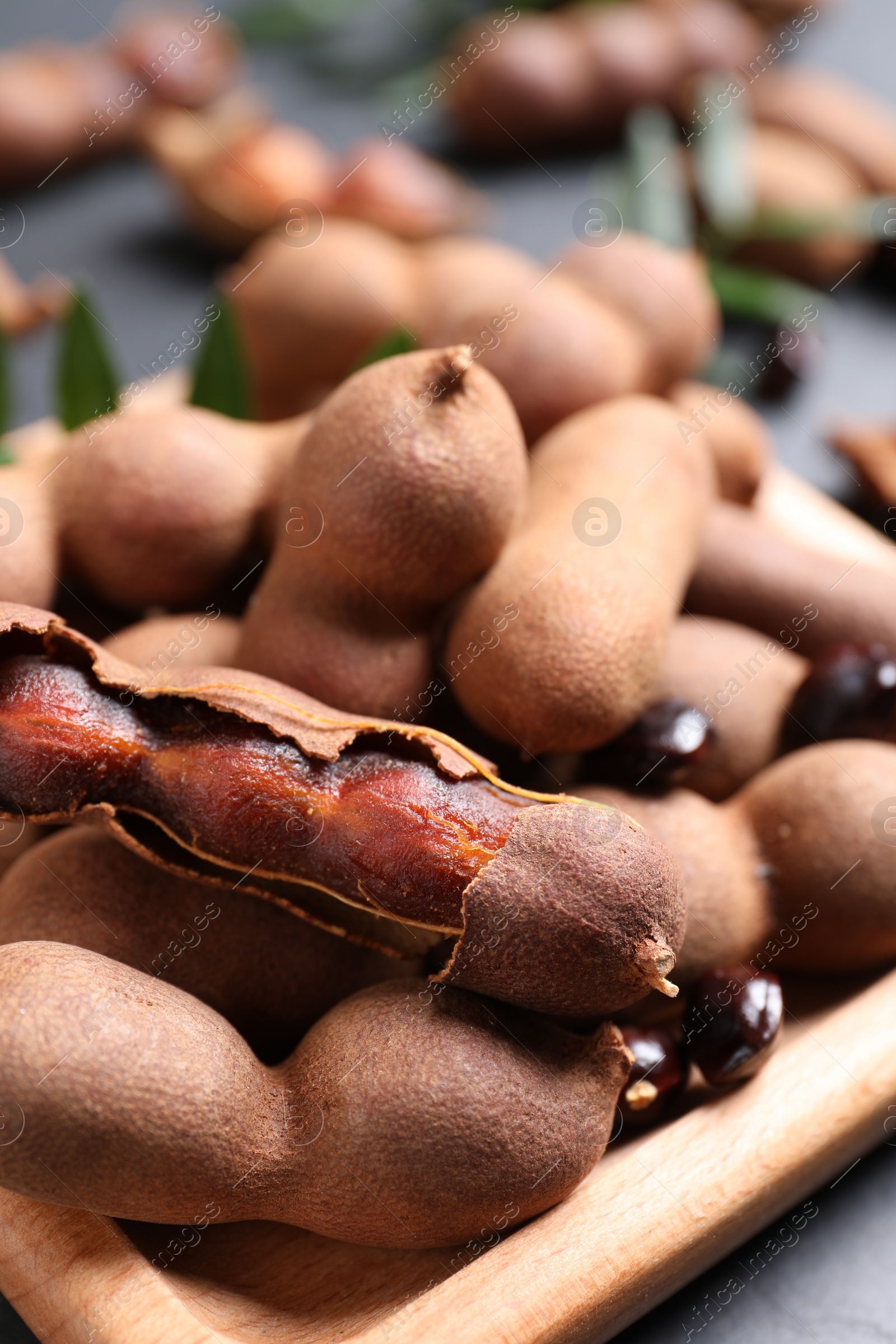 Photo of Wooden plate with delicious ripe tamarinds, closeup
