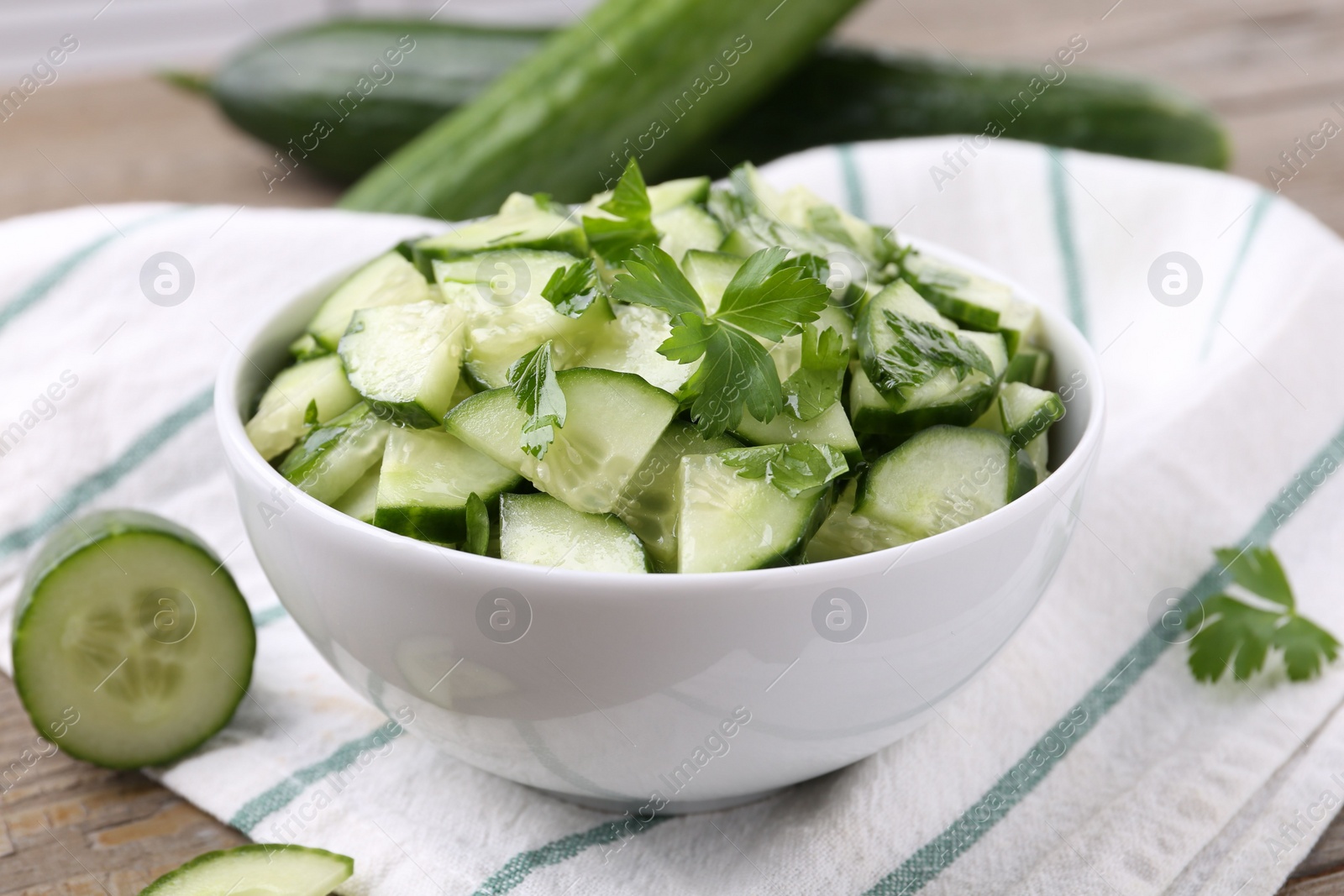 Photo of Delicious cucumber salad in bowl on table