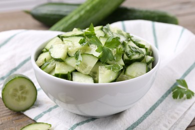 Delicious cucumber salad in bowl on table