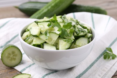 Photo of Delicious cucumber salad in bowl on table