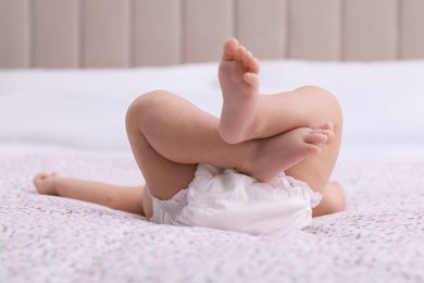 Photo of Little baby in diaper on bed, closeup