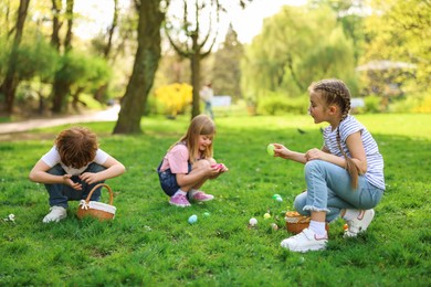 Easter celebration. Cute little children hunting eggs outdoors