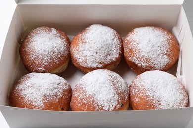 Delicious sweet buns with powdered sugar in box, closeup