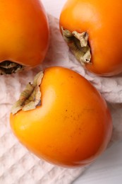 Photo of Delicious ripe persimmons on white table, top view