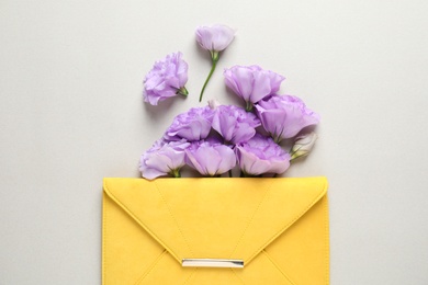 Beautiful Eustoma flowers and envelope on gray background