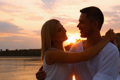 Photo of Happy romantic couple spending time together on beach at sunset
