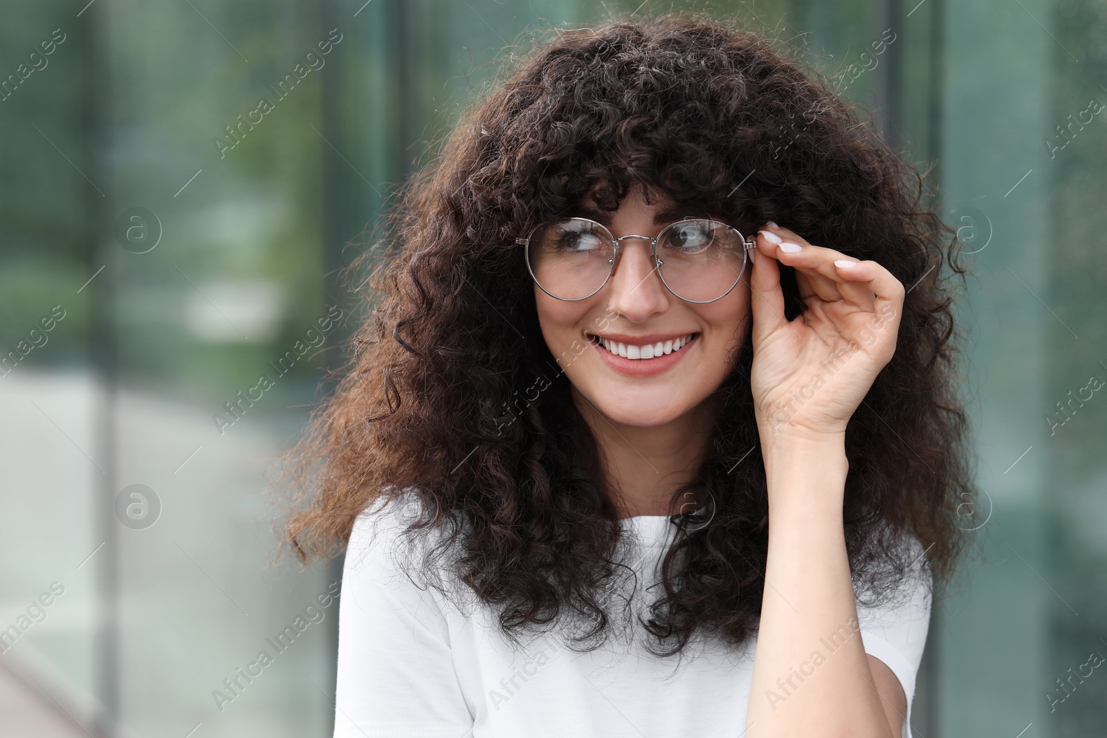 Photo of Portrait of beautiful woman in glasses on blurred background. Attractive lady smiling and posing for camera. Space for text