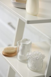 Photo of Cotton buds on white rack in bathroom