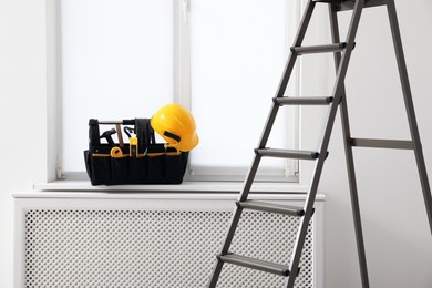 Photo of Window sill with tool box and ladder in room