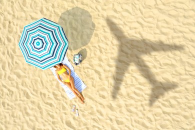 Image of Shadow of airplane and woman resting at sandy coast, aerial view. Summer vacation