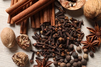 Photo of Different spices and nuts on wooden table, flat lay