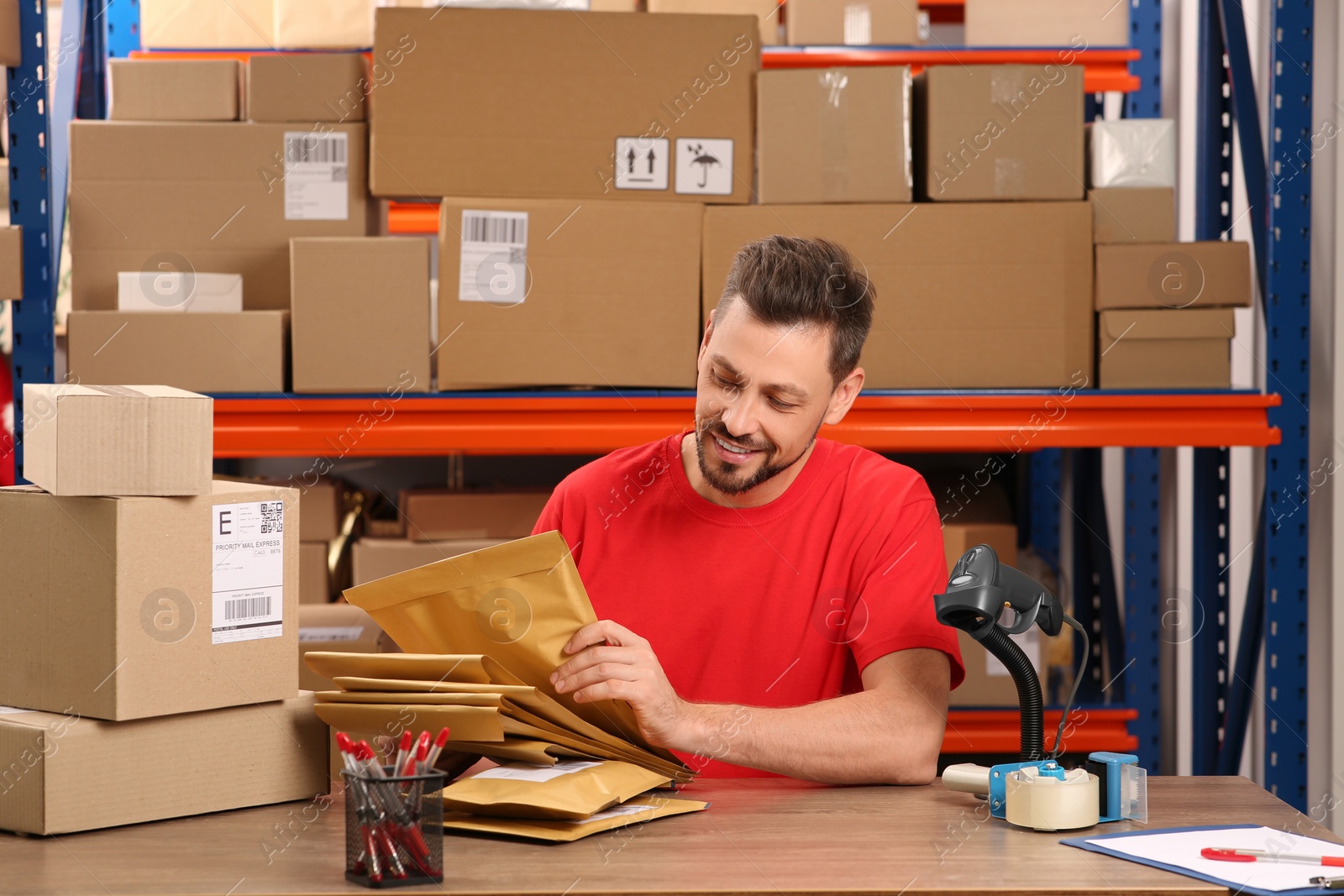 Photo of Post office worker with adhesive paper bags at counter indoors