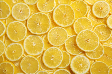 Slices of fresh juicy lemons as background, top view