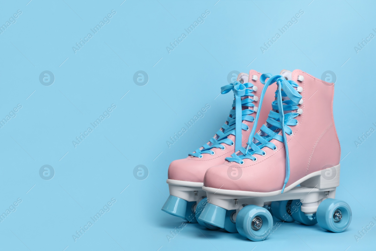 Photo of Pair of stylish quad roller skates on color background. Space for text