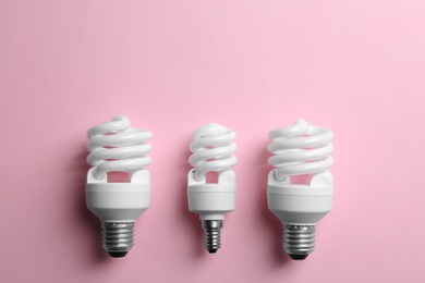 New fluorescent lamp bulbs on pink background, top view