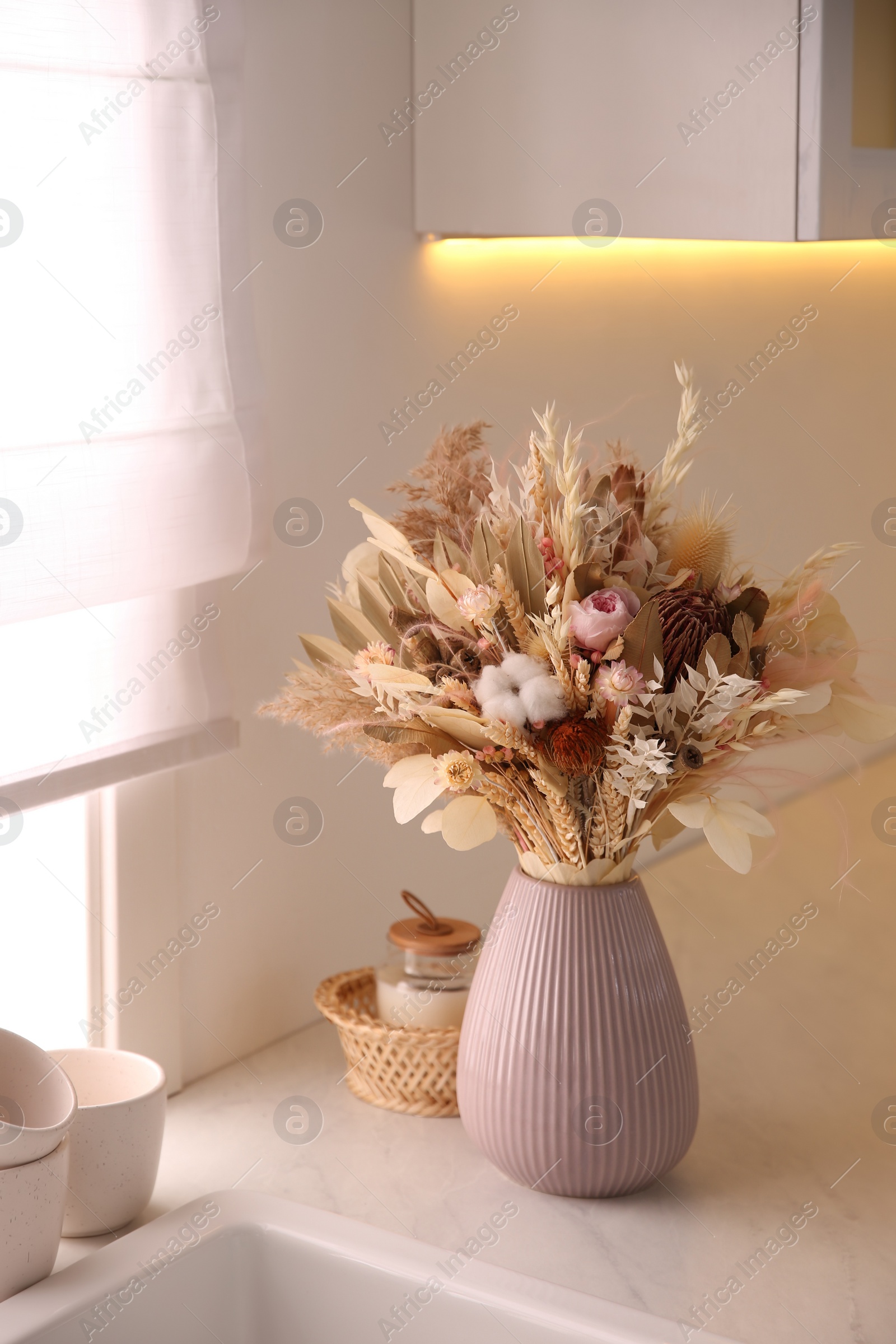 Photo of Bouquet of dry flowers and leaves on countertop in kitchen