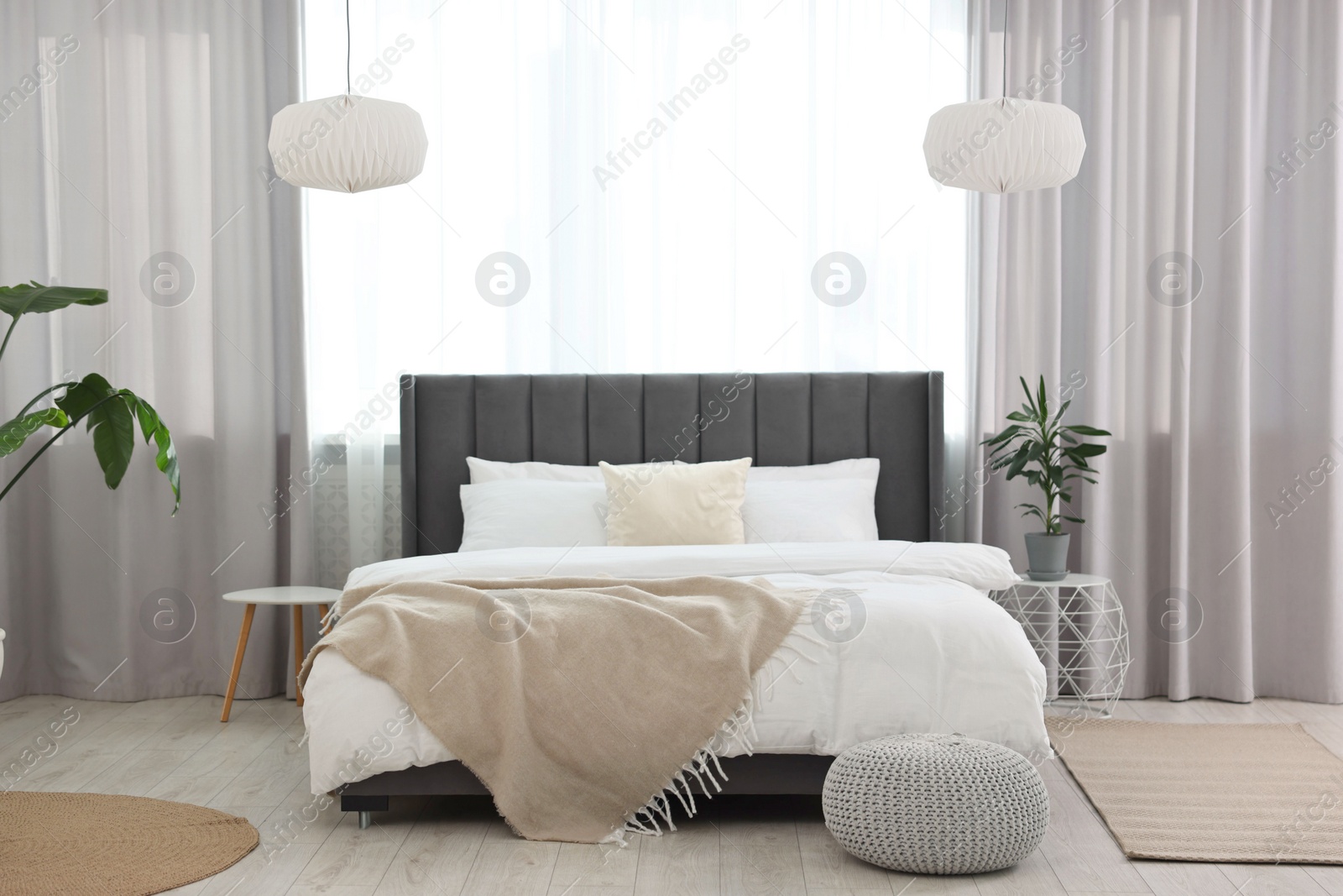 Photo of Soft beige plaid on bed in stylish bedroom. Interior design