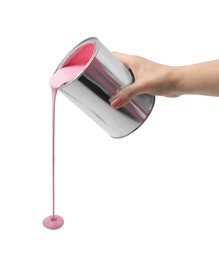 Photo of Woman pouring pink paint from can on white background, closeup