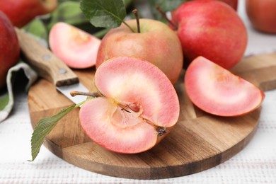 Tasty apples with red pulp on white wooden table, closeup