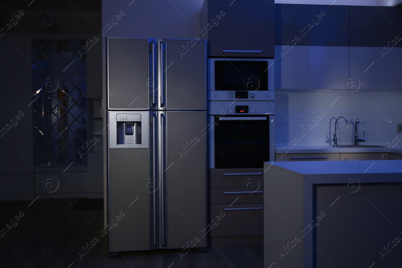 Photo of Kitchen interior with four door refrigerator at night