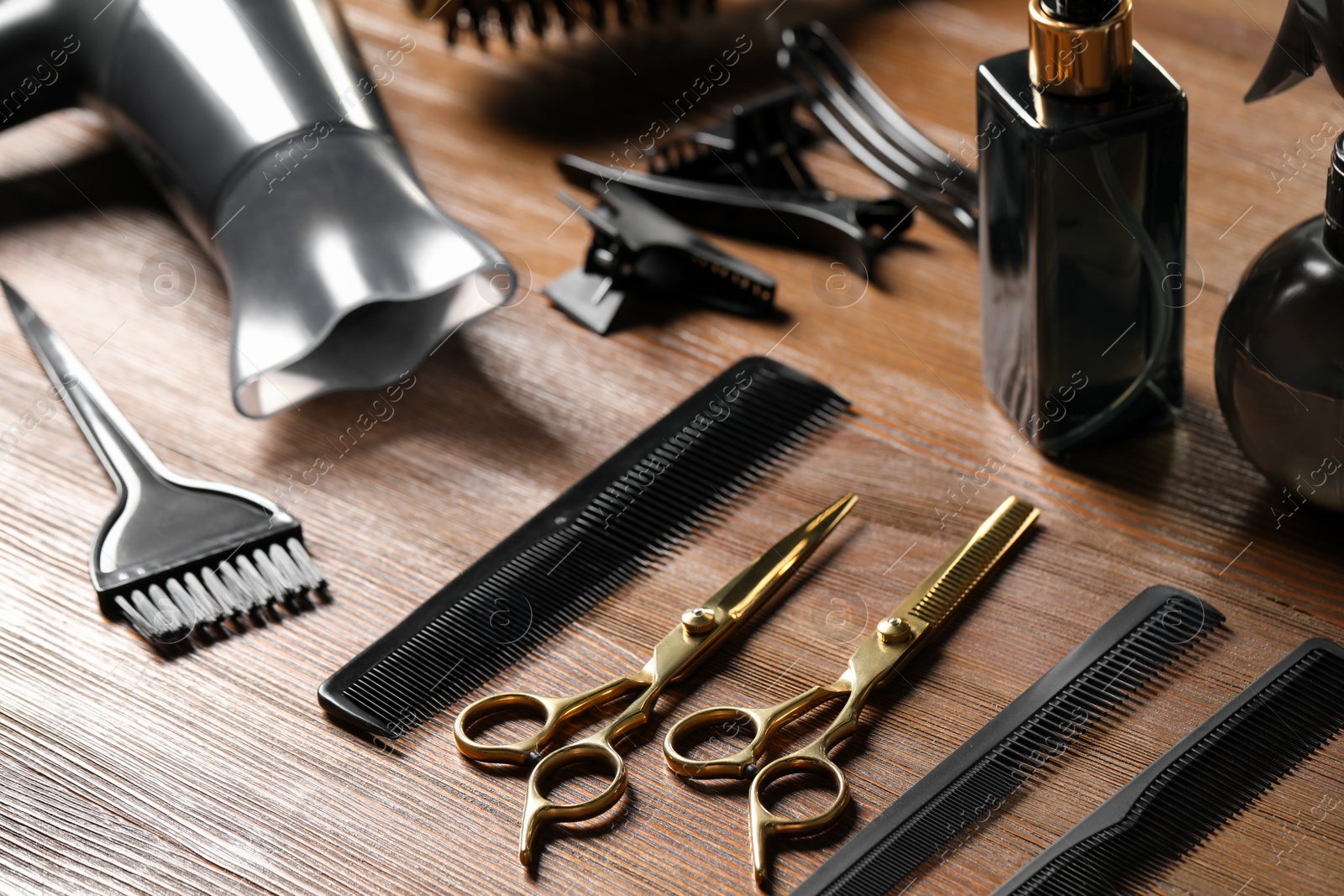 Photo of Hairdresser tools. Different scissors and combs on wooden table, closeup