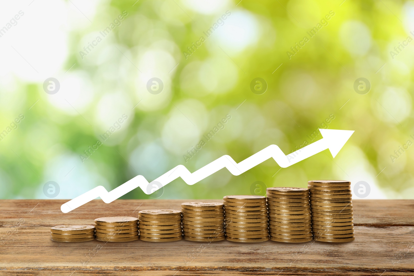 Image of Stacked coins on wooden table against blurred background. Investment concept