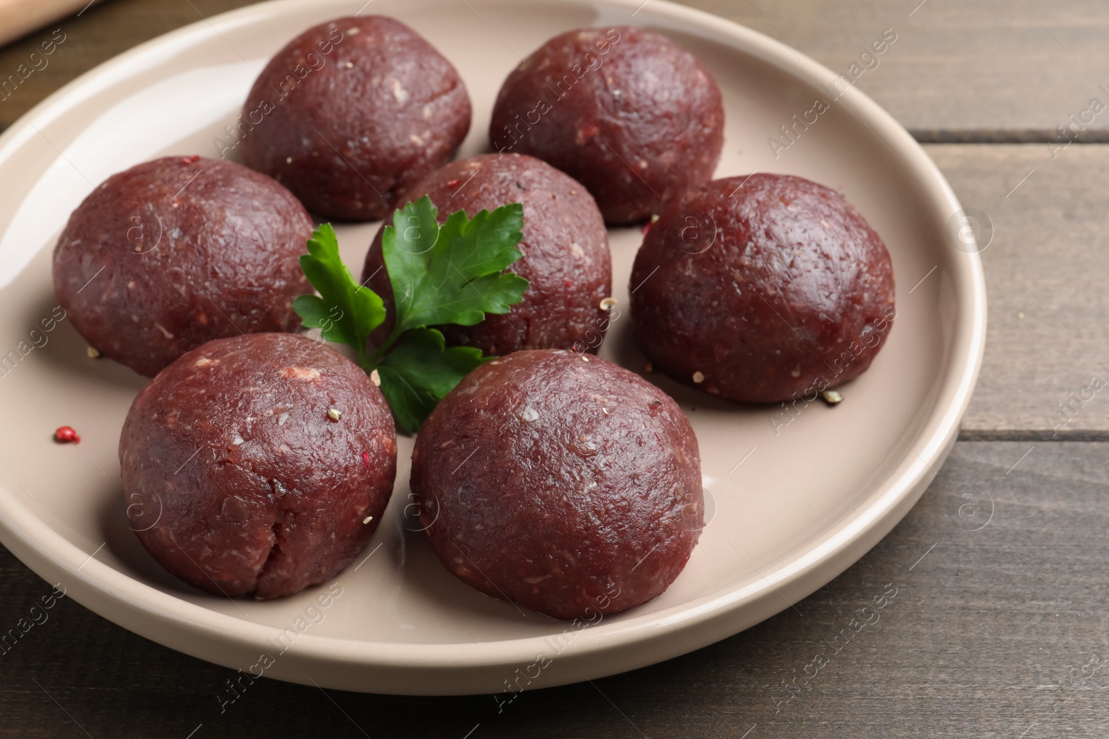 Photo of Many fresh raw meatballs on wooden table, closeup