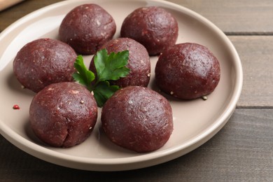 Many fresh raw meatballs on wooden table, closeup