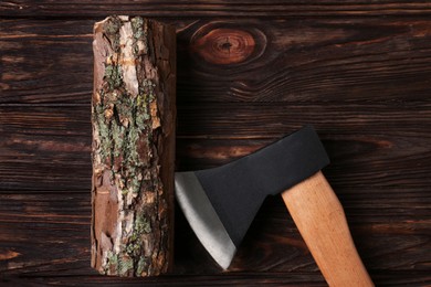 Metal ax and wooden log on table, flat lay