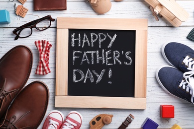 Photo of Flat lay composition with chalkboard, shoes and accessories on wooden background. Father's day celebration