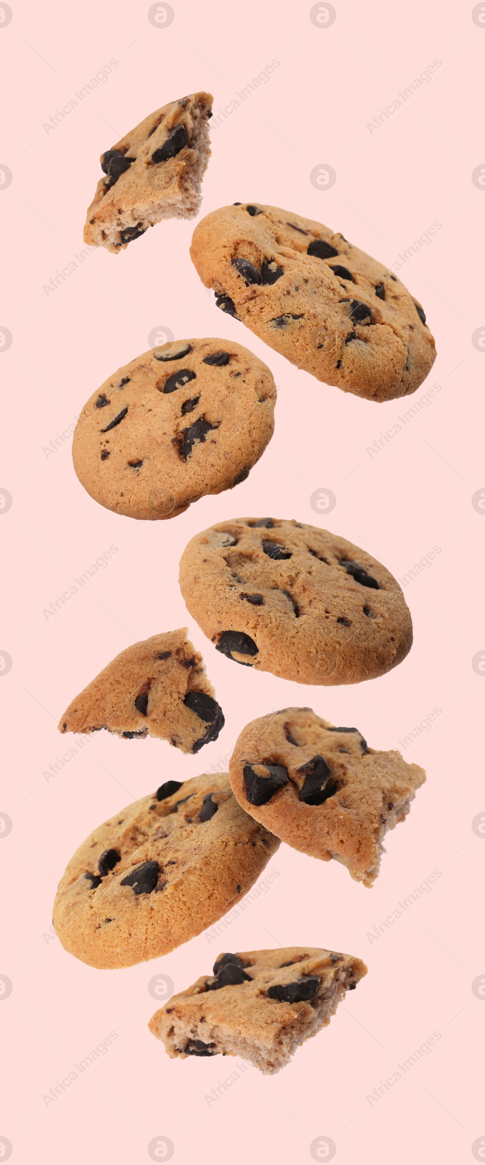 Image of Delicious chocolate chip cookies falling on pink background