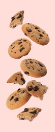 Image of Delicious chocolate chip cookies falling on pink background