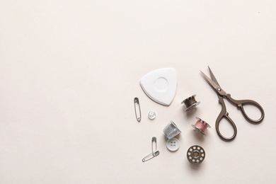 Set of tailoring accessories on light background, top view