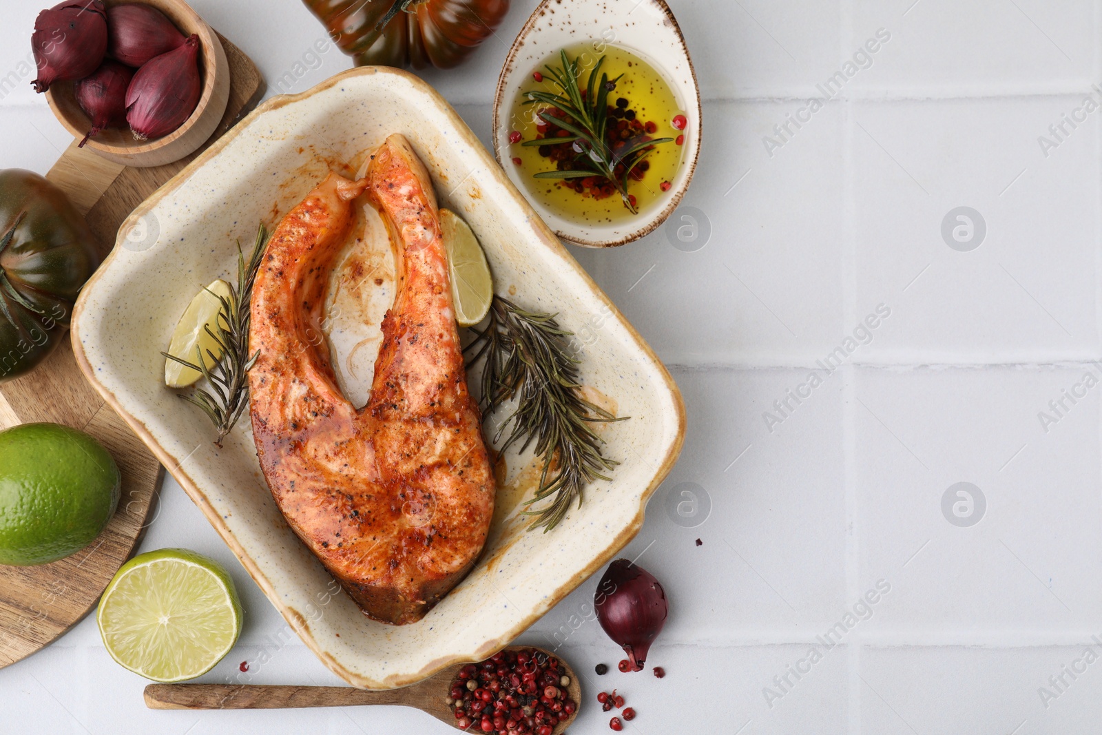 Photo of Freshly cooked fish and other products on white tiled table, flat lay. Space for text