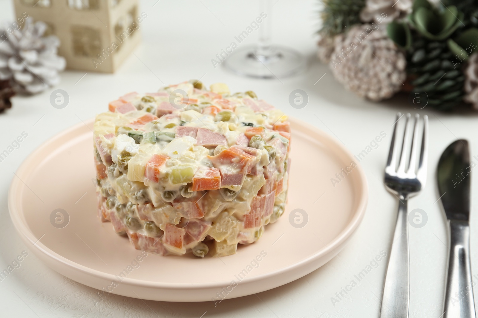 Photo of Traditional russian salad Olivier served on white table