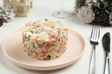 Traditional russian salad Olivier served on white table