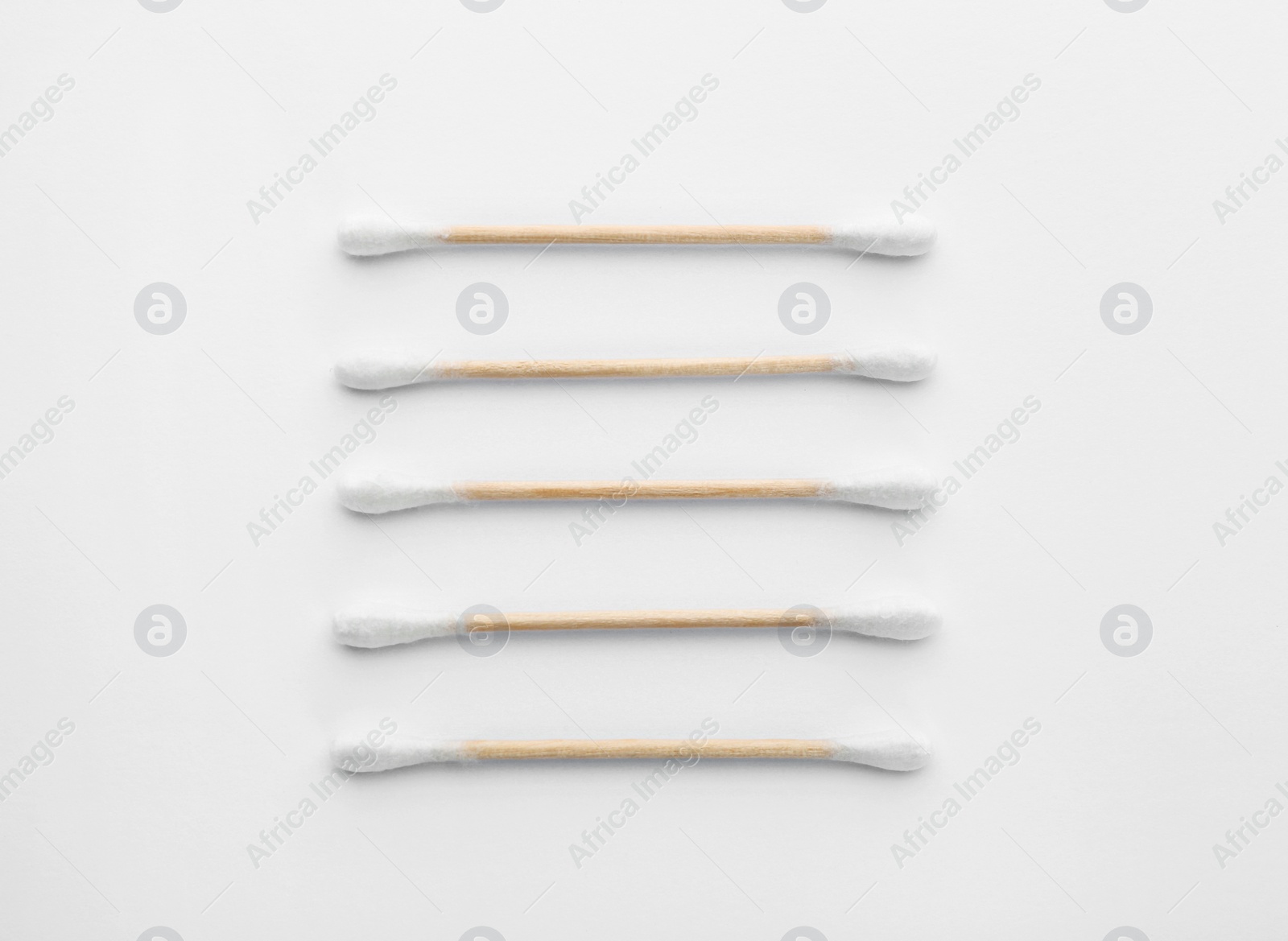 Photo of Wooden cotton swabs on white background, top view