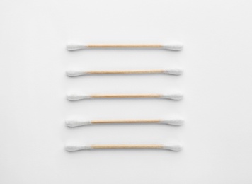 Photo of Wooden cotton swabs on white background, top view