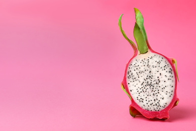 Photo of Half of delicious ripe dragon fruit (pitahaya) on pink background. Space for text