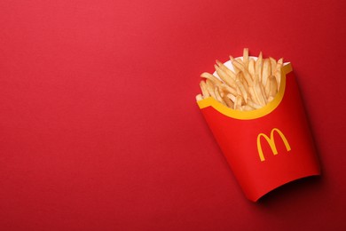 Photo of MYKOLAIV, UKRAINE - AUGUST 12, 2021: Big portion of McDonald's French fries on red background, top view. Space for text