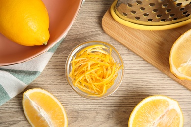 Photo of Lemon zest and fresh fruits on wooden table, flat lay