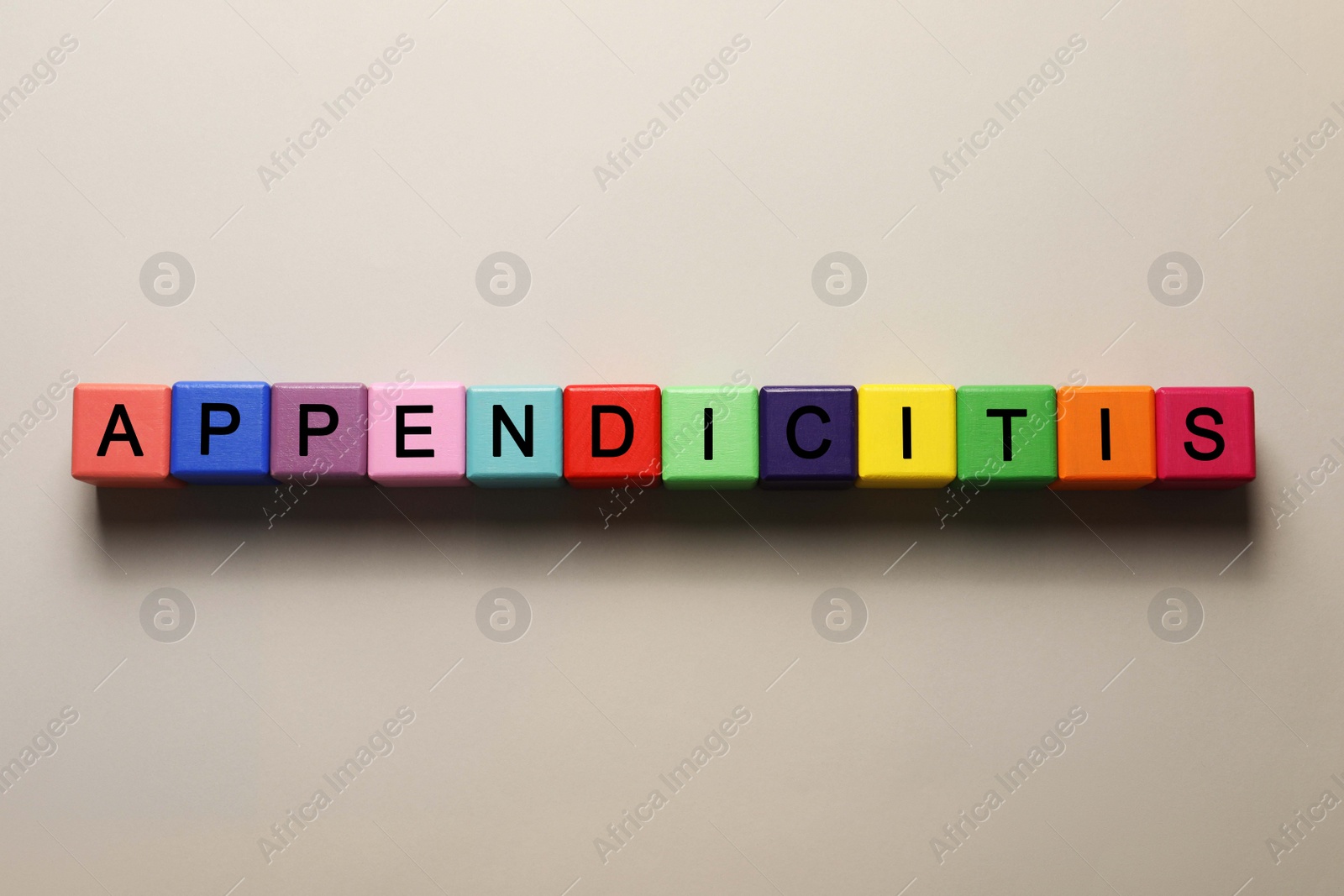 Photo of Word Appendicitis made of color cubes with letters on light background, top view