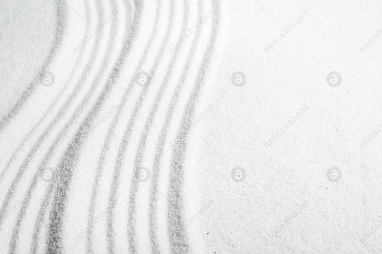 Photo of Zen rock garden. Wave pattern on white sand