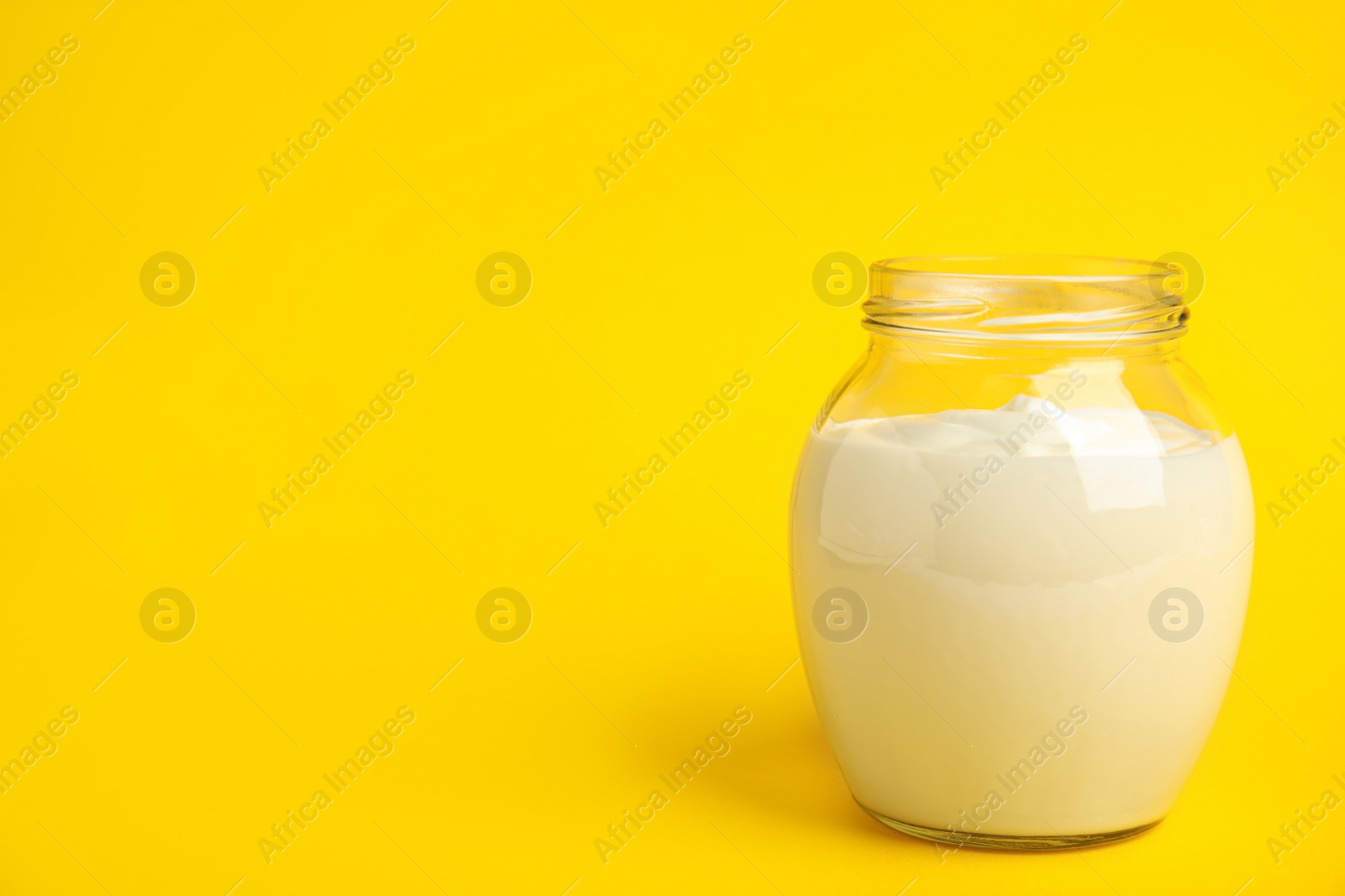 Photo of Tasty organic yogurt on yellow background. Space for text