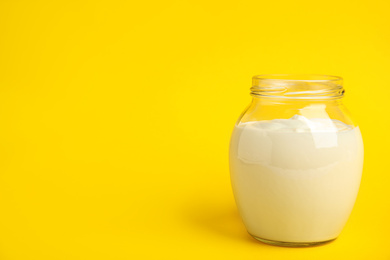 Tasty organic yogurt on yellow background. Space for text